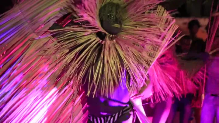 Tocado de paja bajo luz fucsia